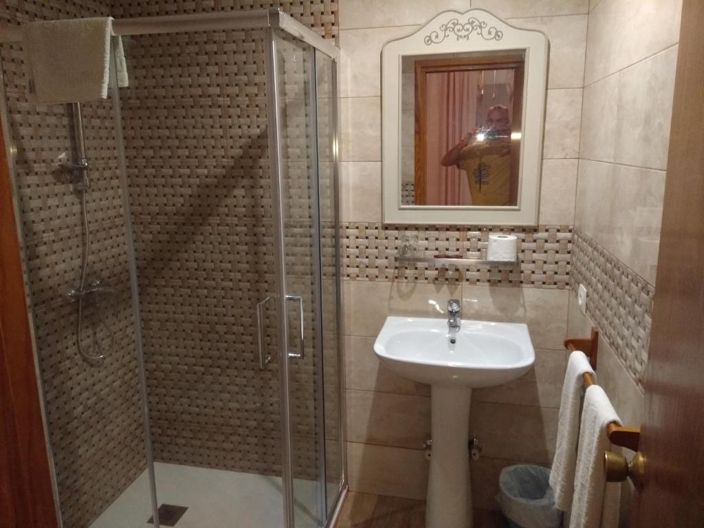 een badkamer met een wastafel en een glazen douche bij Hostal Avenida in Arenas de San Pedro