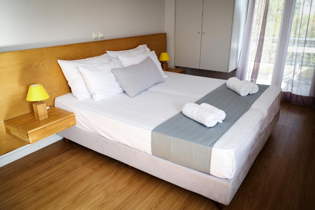 a bedroom with a large white bed with two towels at Sappho Studios in Mytilene