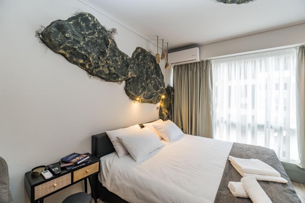 a bedroom with a bed and a large window at GraffitiSuites#Stone in Thessaloniki