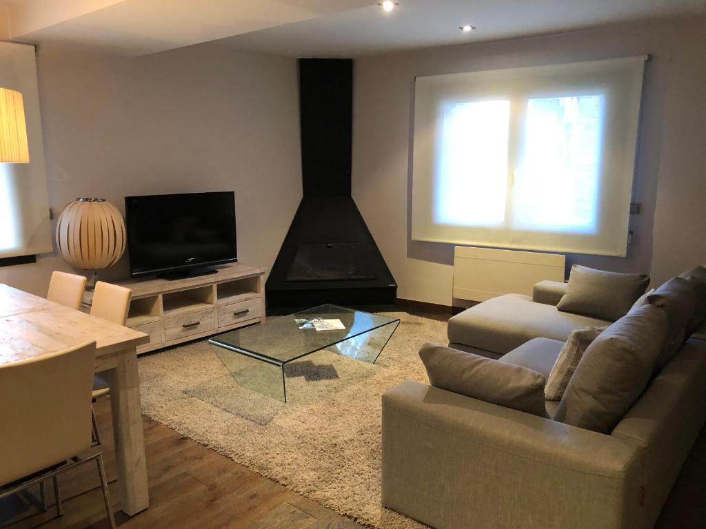 a living room with a couch and a television at Apartament Casa Rey in Vilac