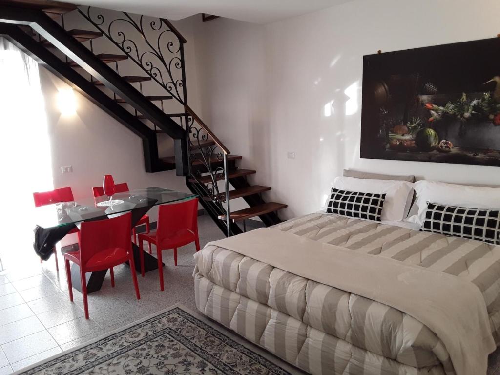 アッシジにあるSuite Luna Biancaのベッドルーム1室(ベッド1台、テーブル、赤い椅子付)