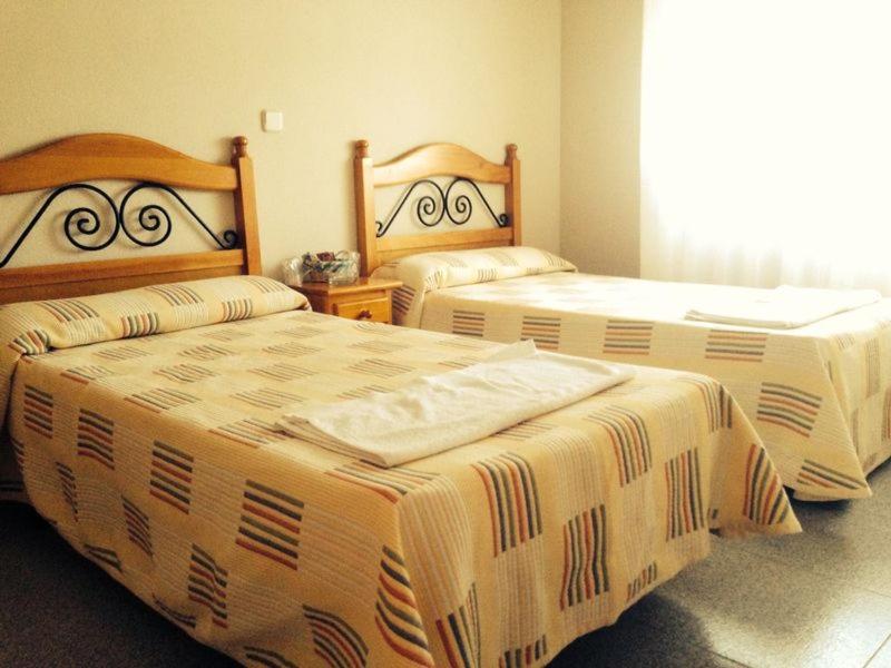 two beds in a hotel room with at Chalet Cantalejo in Cantalejo