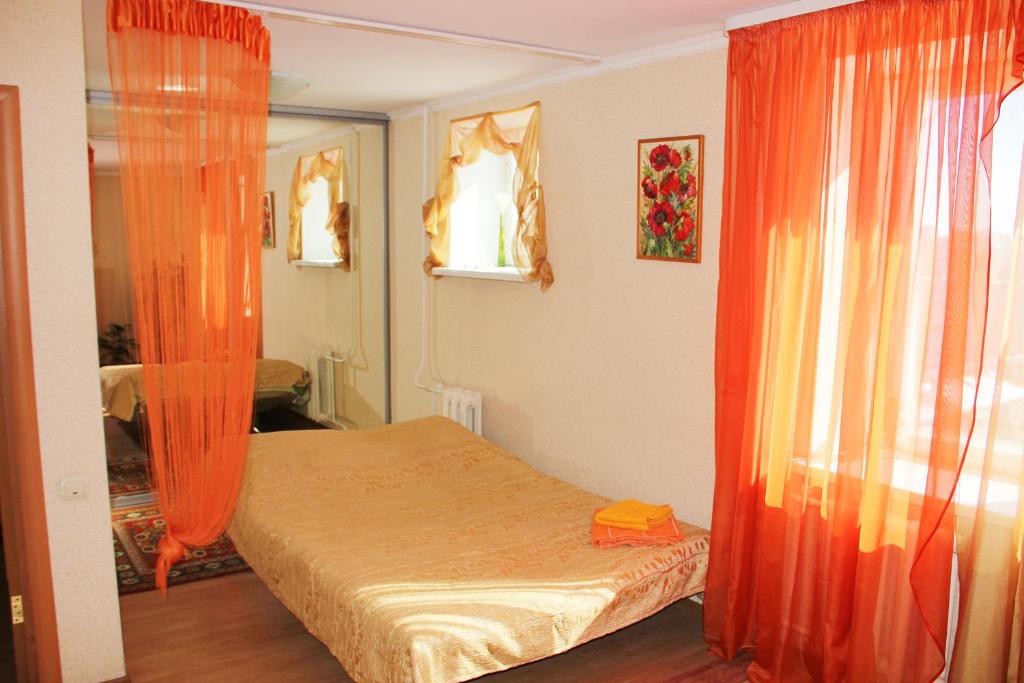 ウファにあるЦентр "Час'の小さなベッドルーム(オレンジ色のカーテン付きのベッド1台付)