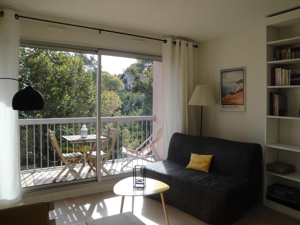 a living room with a couch and a balcony at Résidence Arguin 2 in Arcachon