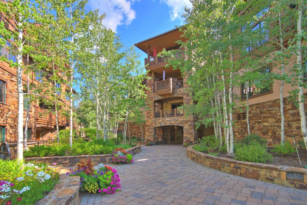 an exterior view of a building with a courtyard with flowers at Arrowhead Village at Beaver Creek in Edwards