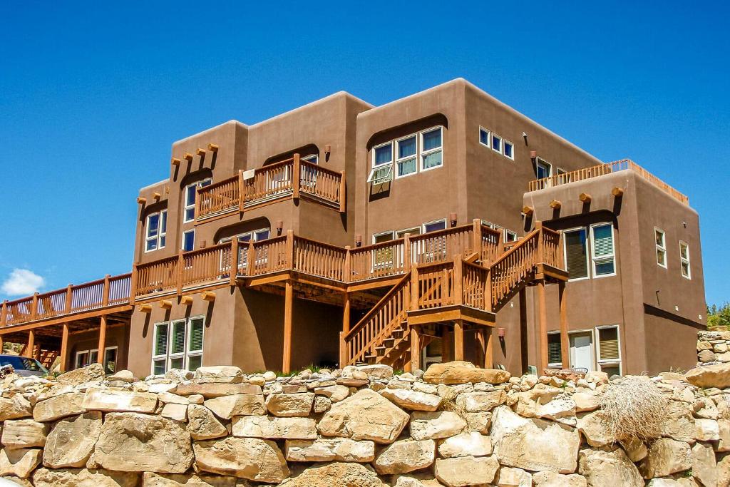 ein großes braunes Haus mit einer Steinmauer in der Unterkunft Slot Canyons Inn Bed & Breakfast in Escalante