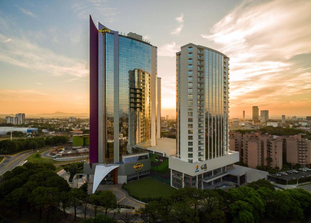 グアダラハラにあるHard Rock Hotel Guadalajaraの日没時の都市の高層ビル2棟