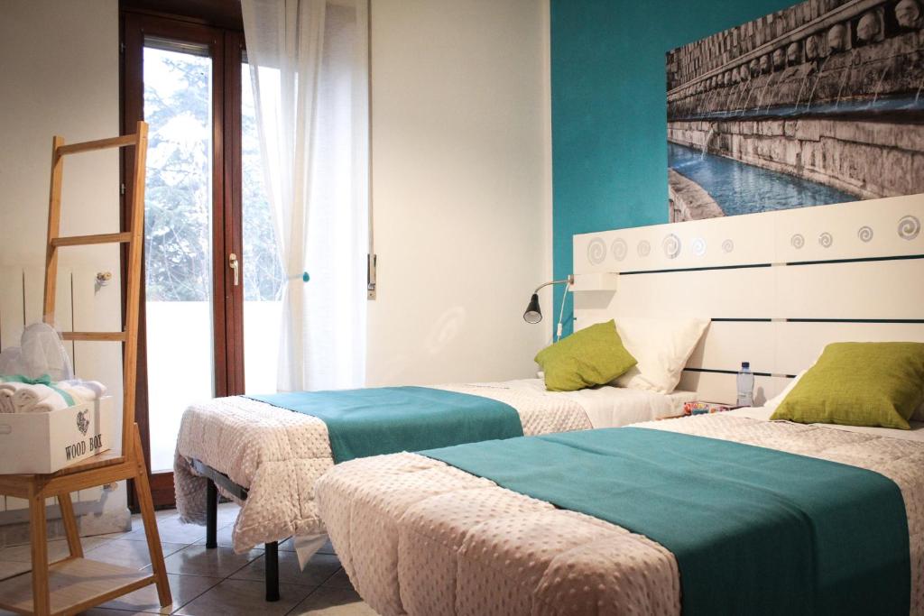2 camas en una habitación con paredes azules en B&B del Viale, en LʼAquila
