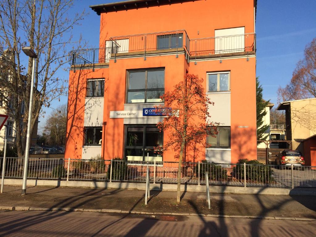 een oranje gebouw aan de straatkant bij 58 Puschkinstraße in Lutherstadt Wittenberg