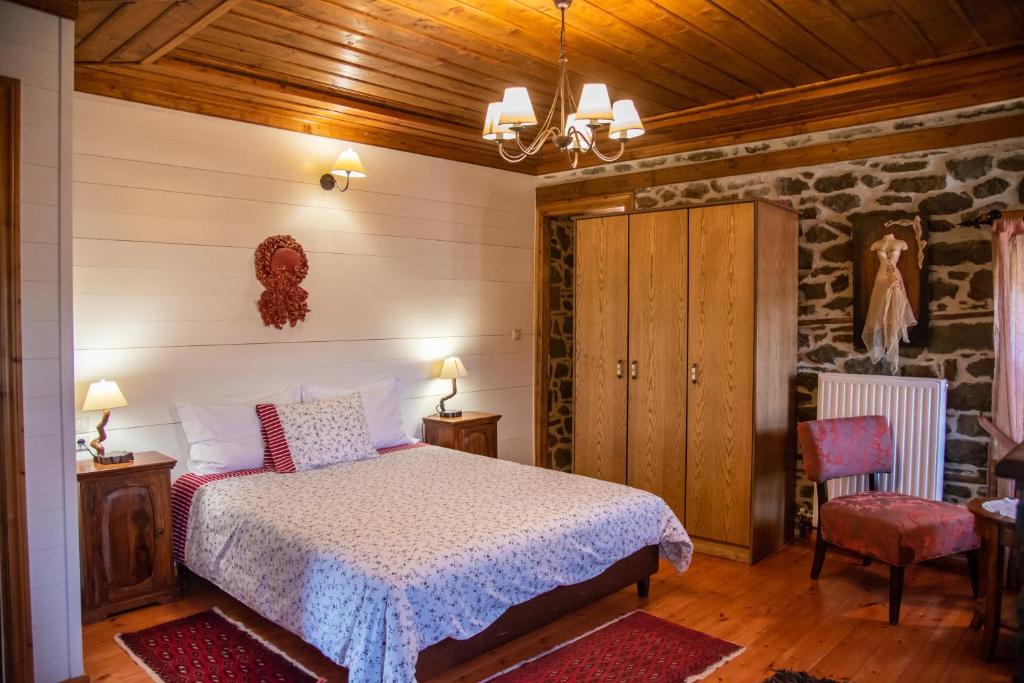 a bedroom with a bed and a stone wall at Archontiko Aiolides in Kríkellon