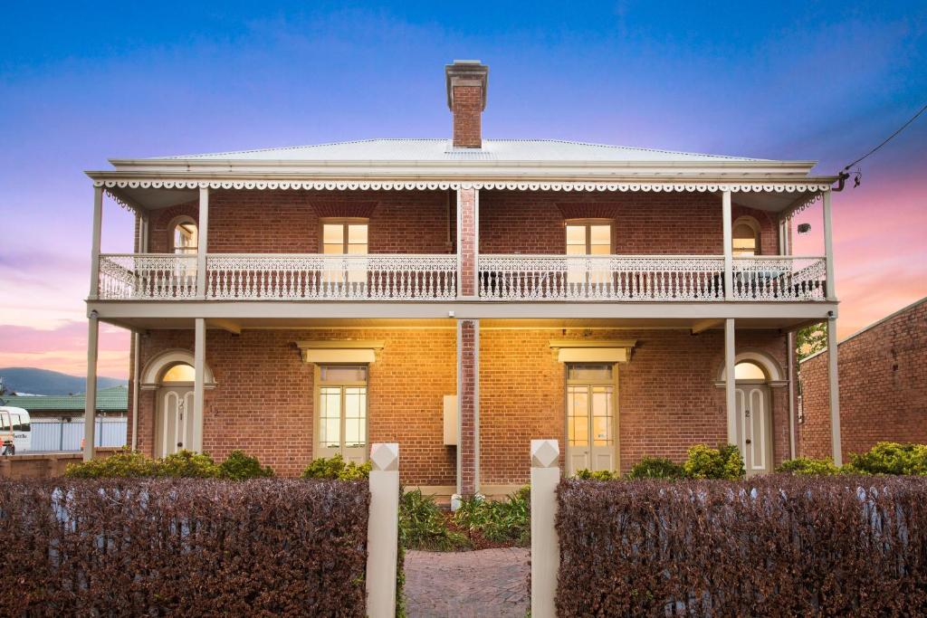 a brick house with a balcony on top of it at Peppertree Terraces in Mudgee