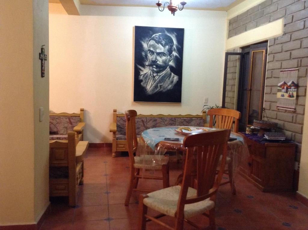 un comedor con mesa, sillas y una pintura en Loft El Rosario, en Tlayacapan