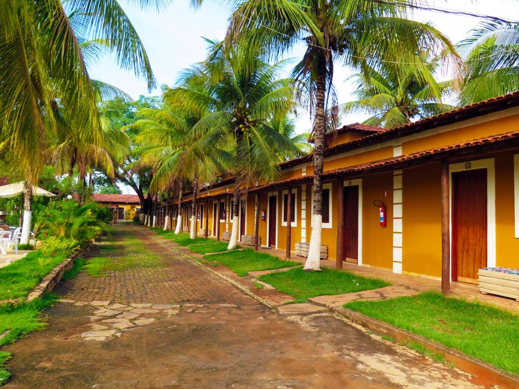 a row of houses with palm trees next to a street at Pousada Grande Rio in Pirapora