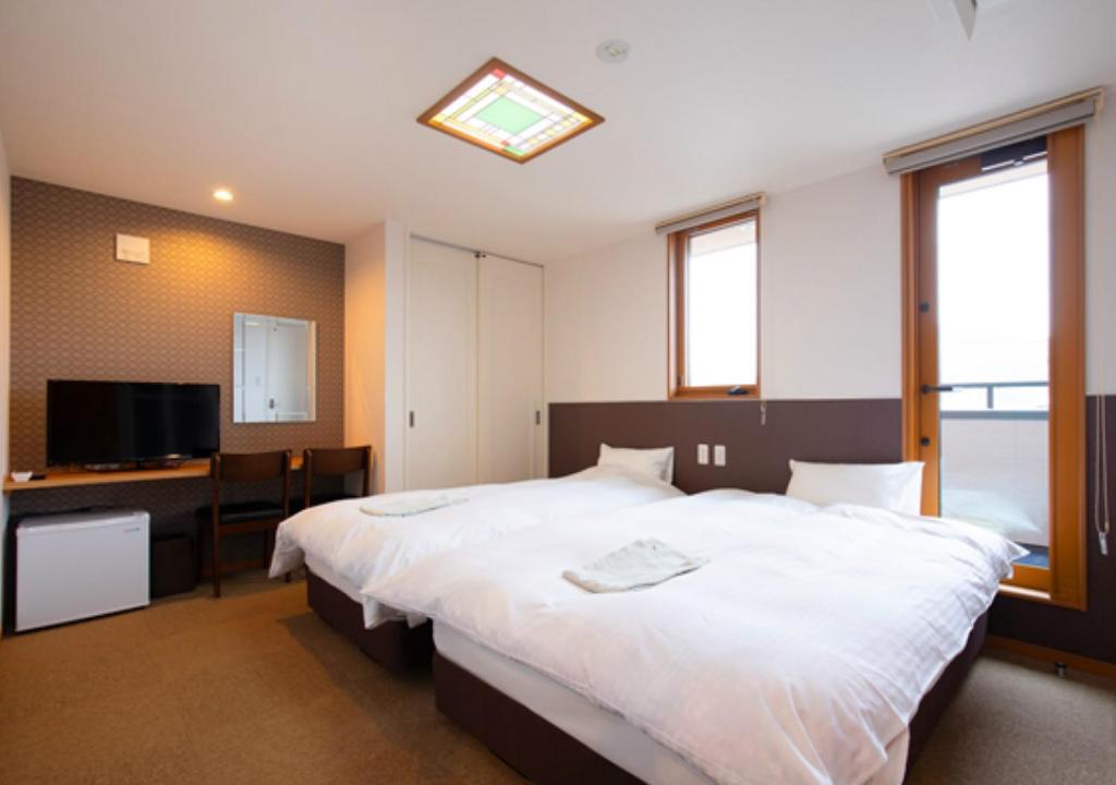 Wright Style في ناووشيما: غرفة نوم مع سرير أبيض كبير ومكتب