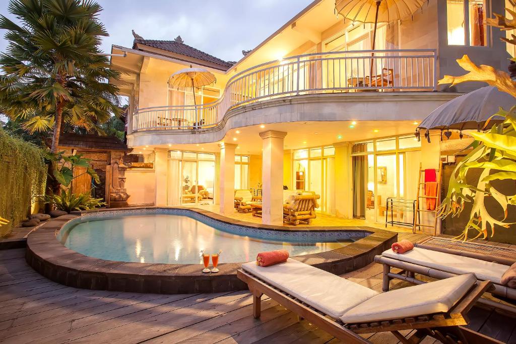 uma casa com piscina em frente a uma casa em Pariliana em Ubud