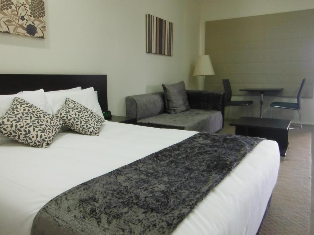 une chambre d'hôtel avec un lit et un salon dans l'établissement Injune Motor Inn, à Injune