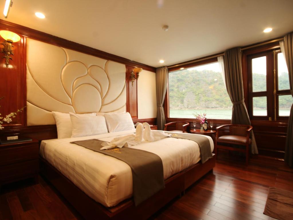a bedroom with a large bed and a large window at Calypso Cruises in Ha Long