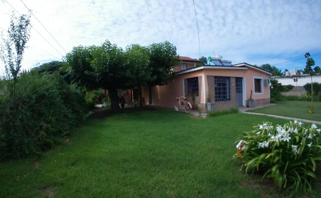 uma casa com um quintal com um relvado verde em Cerro Chico em Villa Cura Brochero