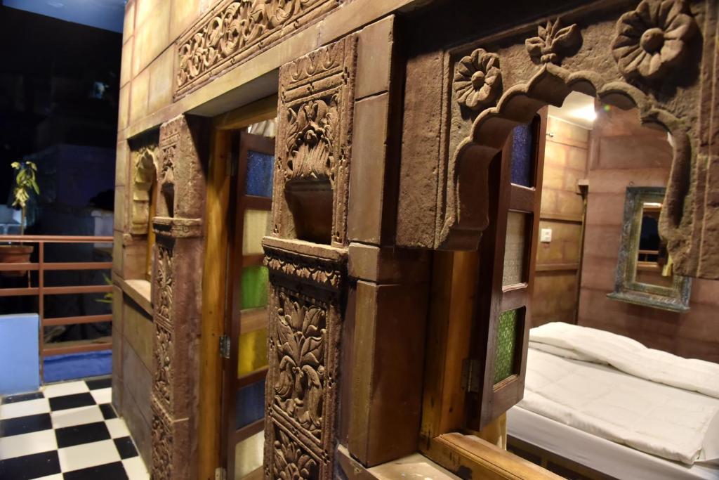 a wooden door in a room with a bed at Dev Kothi - Boutique Heritage Stay in Jodhpur
