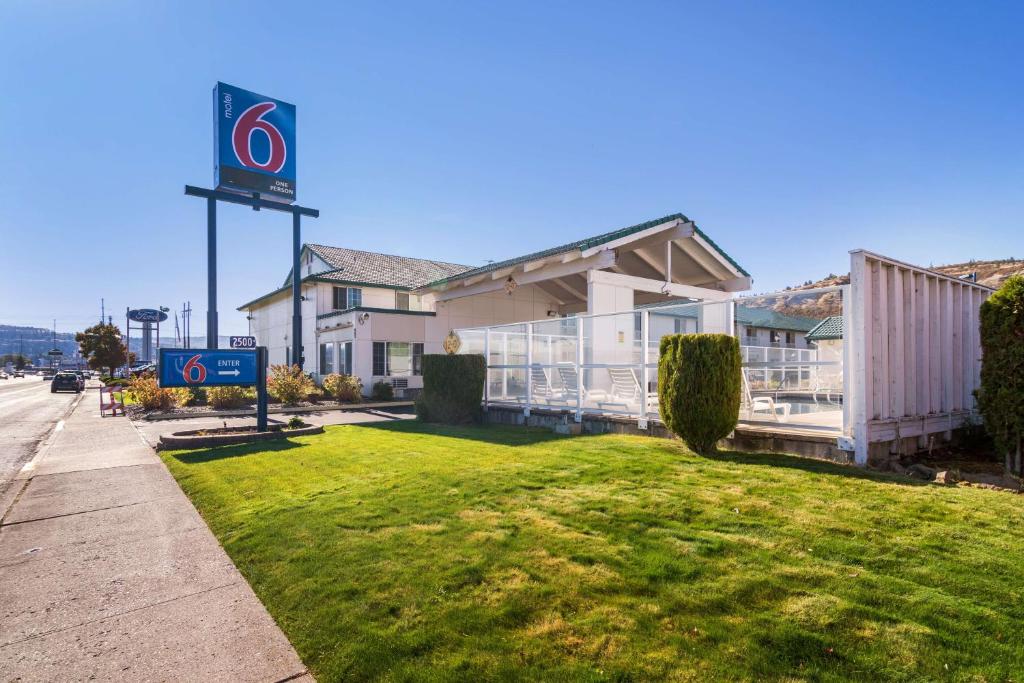 un bâtiment avec un panneau sur le côté de la route dans l'établissement Motel 6-The Dalles, OR, à The Dalles