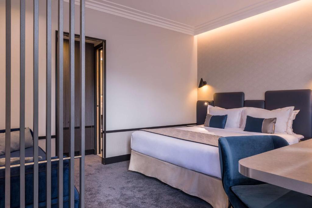 ブローニュ・ビヤンクールにあるベストウエスタン セレクト ホテルのベッドとテーブルが備わるホテルルームです。