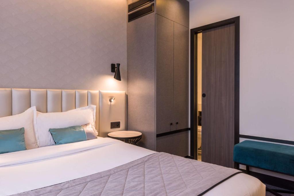 a bedroom with a large white bed with blue pillows at Best Western Select Hotel in Boulogne-Billancourt