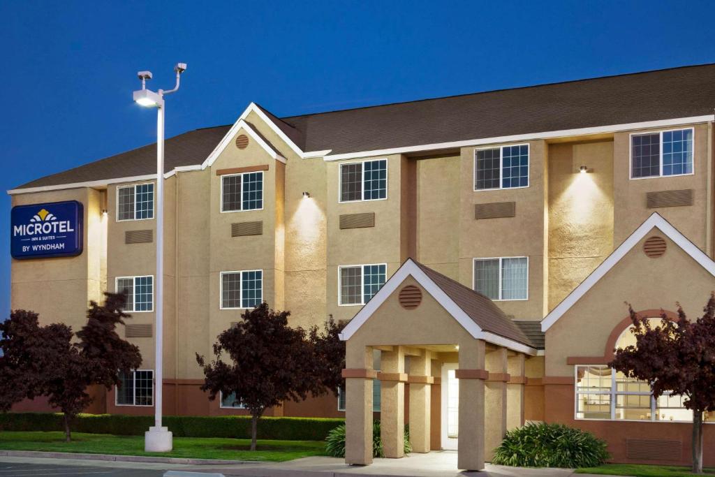 Un gran edificio con un cartel delante. en Microtel Inn &amp; Suites Lodi, en Lodi