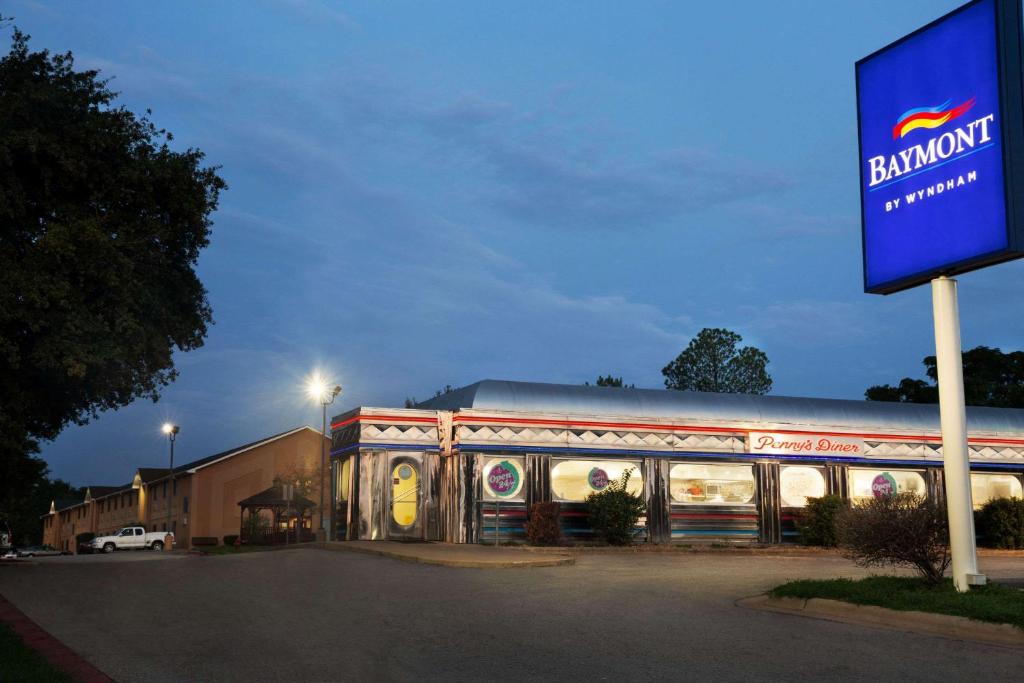 a building with a sign in front of it at Baymont by Wyndham Hearne in Hearne