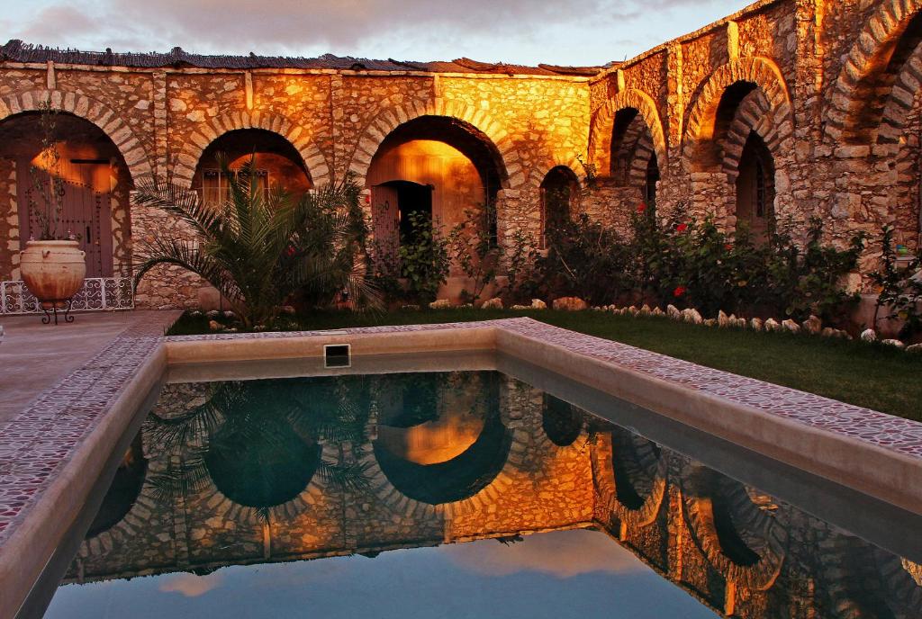 une maison avec une piscine en face d'un bâtiment dans l'établissement Villa Salvatore, à Ghazoua
