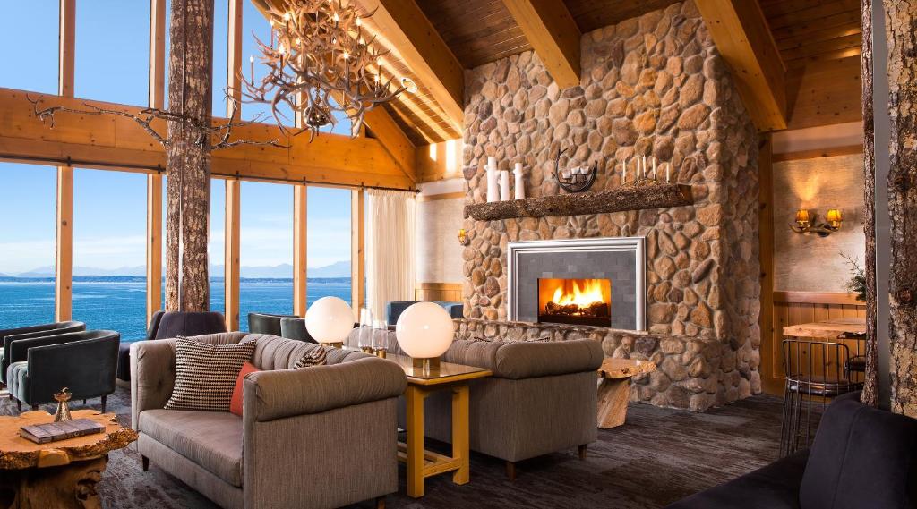 a living room with a large stone fireplace at The Edgewater, a Noble House Hotel in Seattle