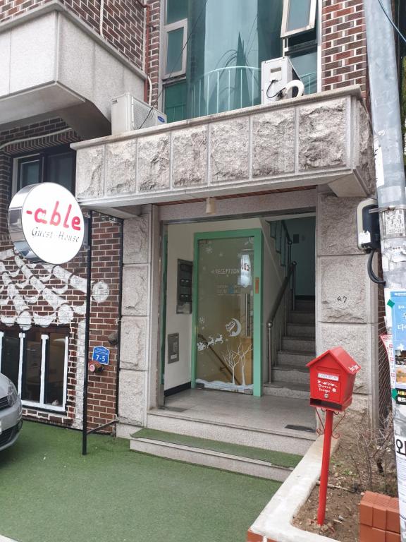 a entrance to a building with a green door at Able Guesthouse Hongdae in Seoul