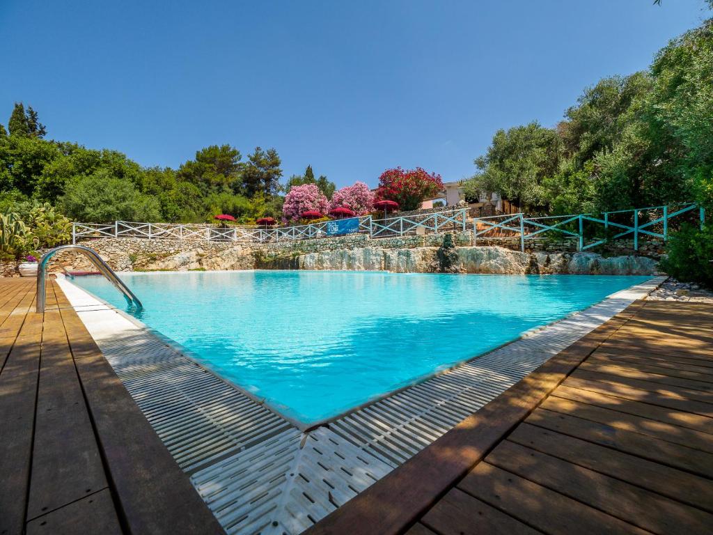 uma grande piscina com água azul num deque de madeira em Antica Masseria Rottacapozza em Torre San Giovanni Ugento