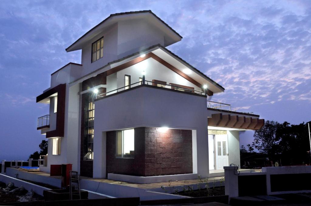 a large house with lights on top of it at Clifftop in Dapoli