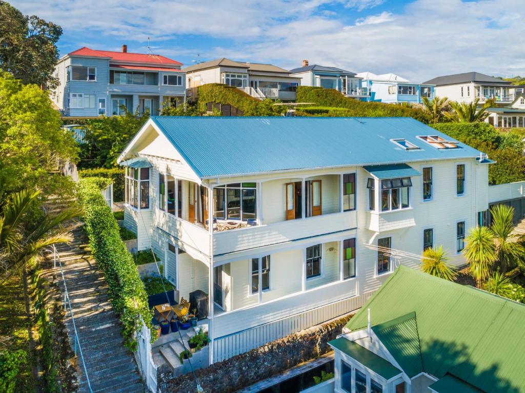 une vue aérienne sur une maison blanche avec un toit bleu dans l'établissement Devonport Harbour View, à Auckland