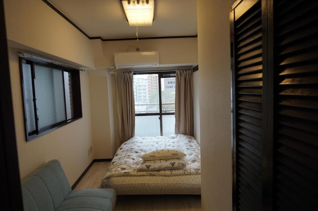 a small bedroom with a bed and a window at CUBIC.30 in Hiroshima