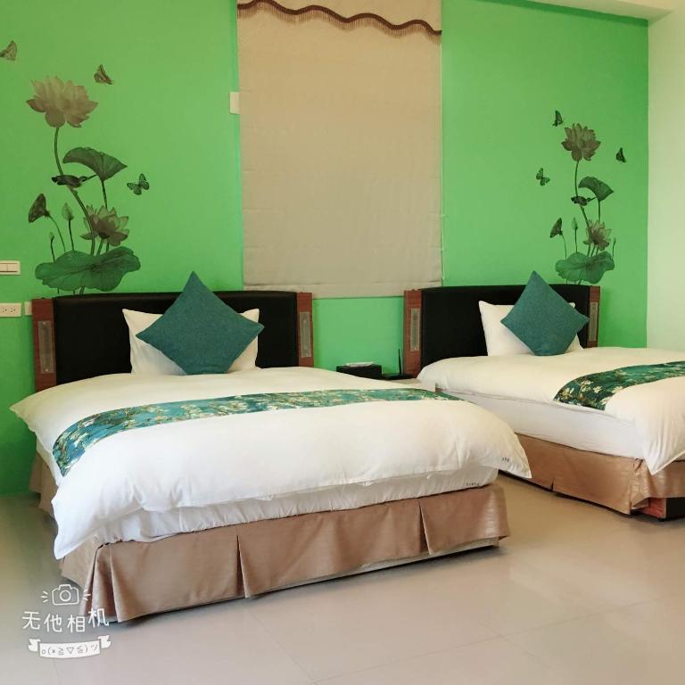two beds in a room with green walls at Fish Fun House in Hualien City