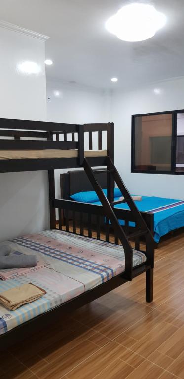 Zwei Etagenbetten befinden sich in einem Zimmer. in der Unterkunft KDC Homes (Gold) in Puerto Princesa