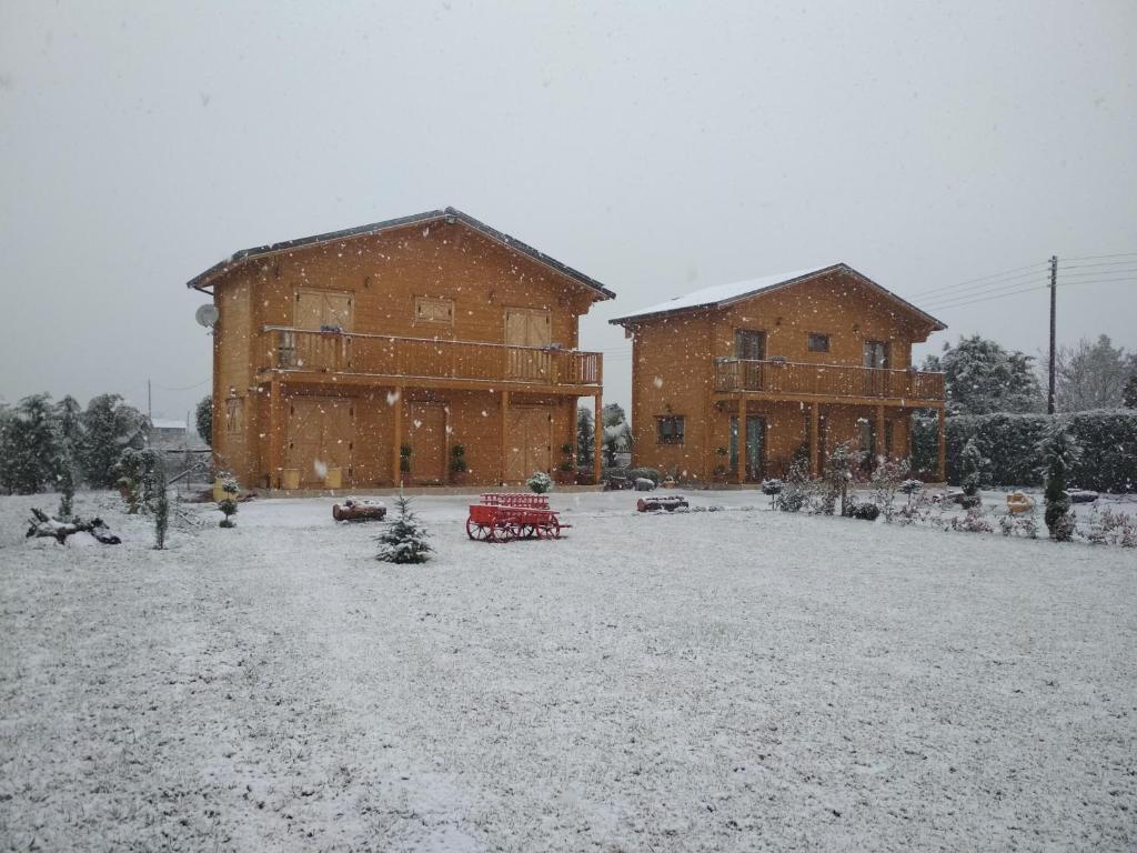 dois grandes edifícios de tijolos com neve no chão em Kastor Chalets em Ampelokipoi
