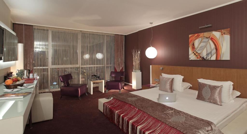 アンカラにあるCity Hotel Ankaraの大きなベッドとデスクが備わるホテルルームです。