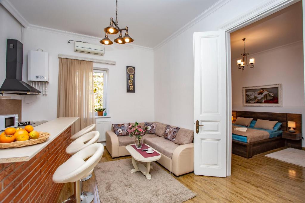 een woonkamer met een bank en een tafel bij Tbilisi Central apartment in Tbilisi City
