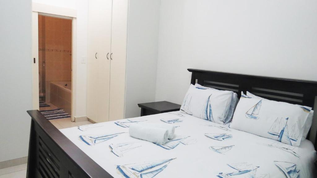 Cama con sábanas y almohadas azules y blancas en Balooga No. 22, en Margate