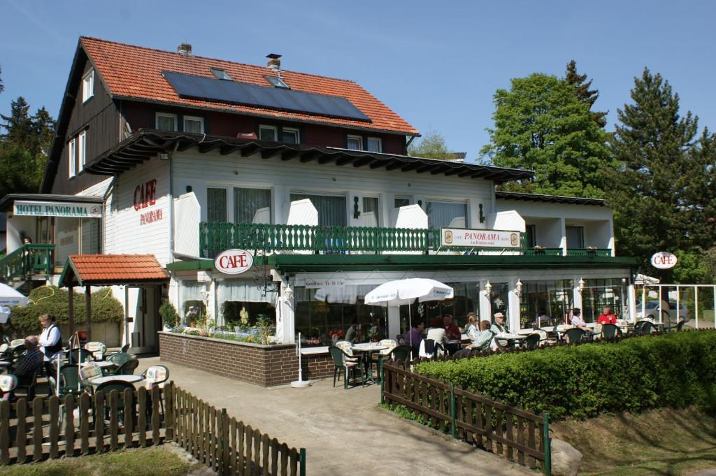 a building with a restaurant with people sitting at tables at Hotel und Cafe Panorama in Braunlage