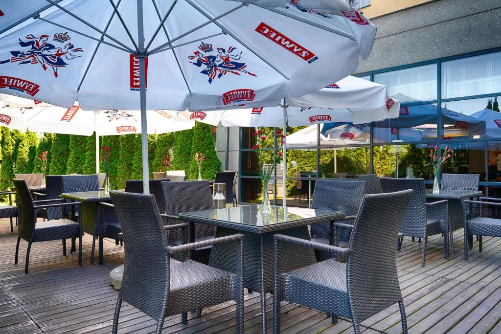 a patio with tables and chairs and umbrellas at Focus Hotel Gdańsk in Gdańsk
