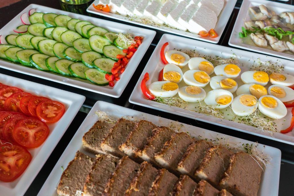 a buffet of food with eggs meats and vegetables at Focus Hotel Gdańsk in Gdańsk