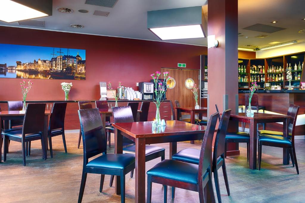a restaurant with tables and chairs and a bar at Focus Hotel Gdańsk in Gdańsk
