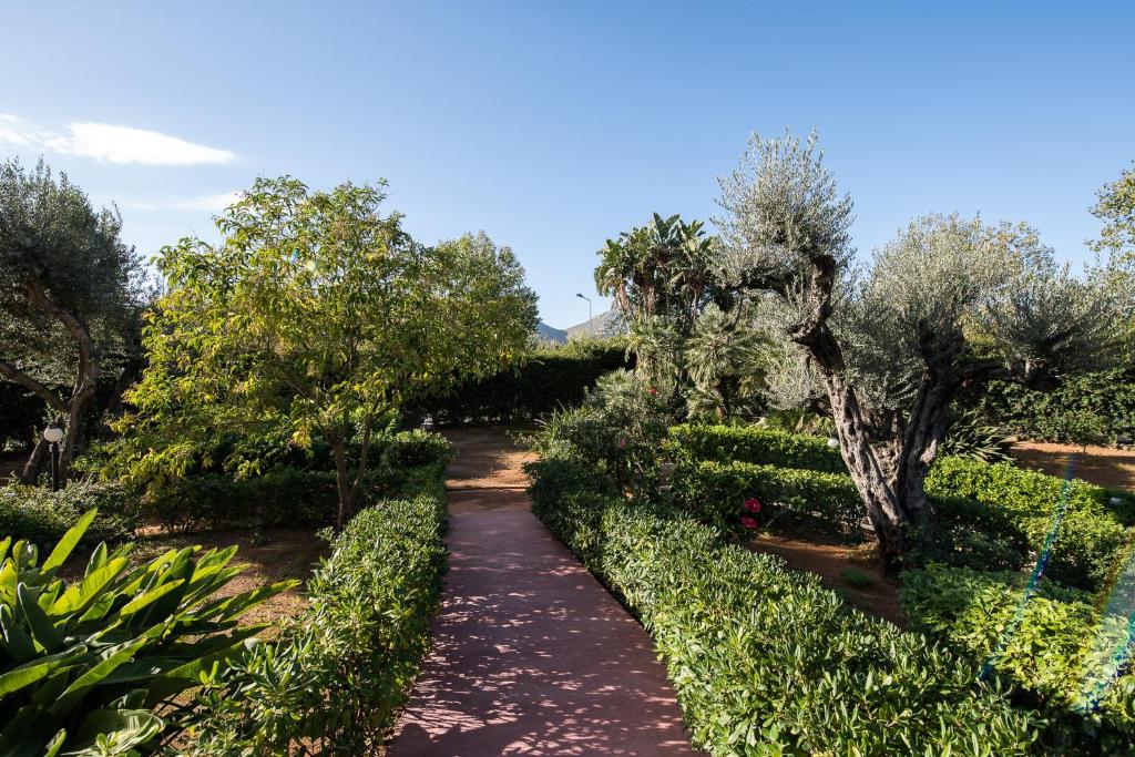 a path through a garden with trees and bushes at Il Giardino di Venere in Mondello