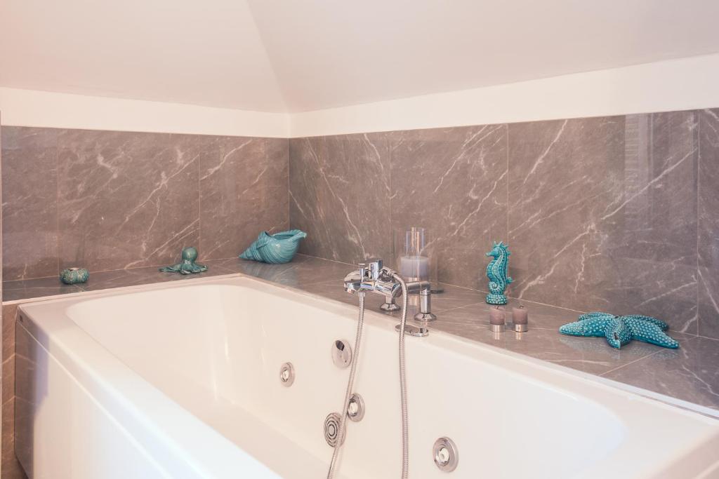 a bath tub in a bathroom with a marble wall at Il Giardino di Venere in Mondello