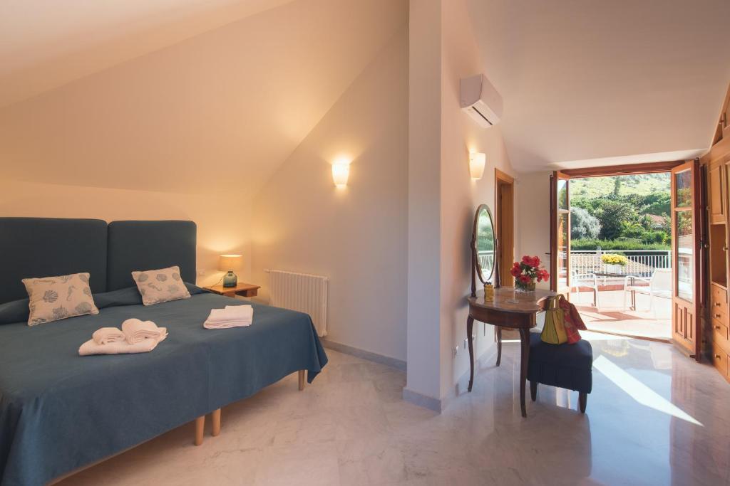 a bedroom with a bed and a table and a window at Il Giardino di Venere in Mondello