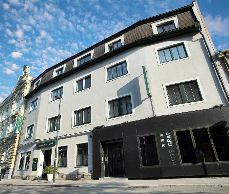 ein großes weißes Gebäude in einer Stadtstraße in der Unterkunft Hotel-Gasthof Graf in Sankt Pölten