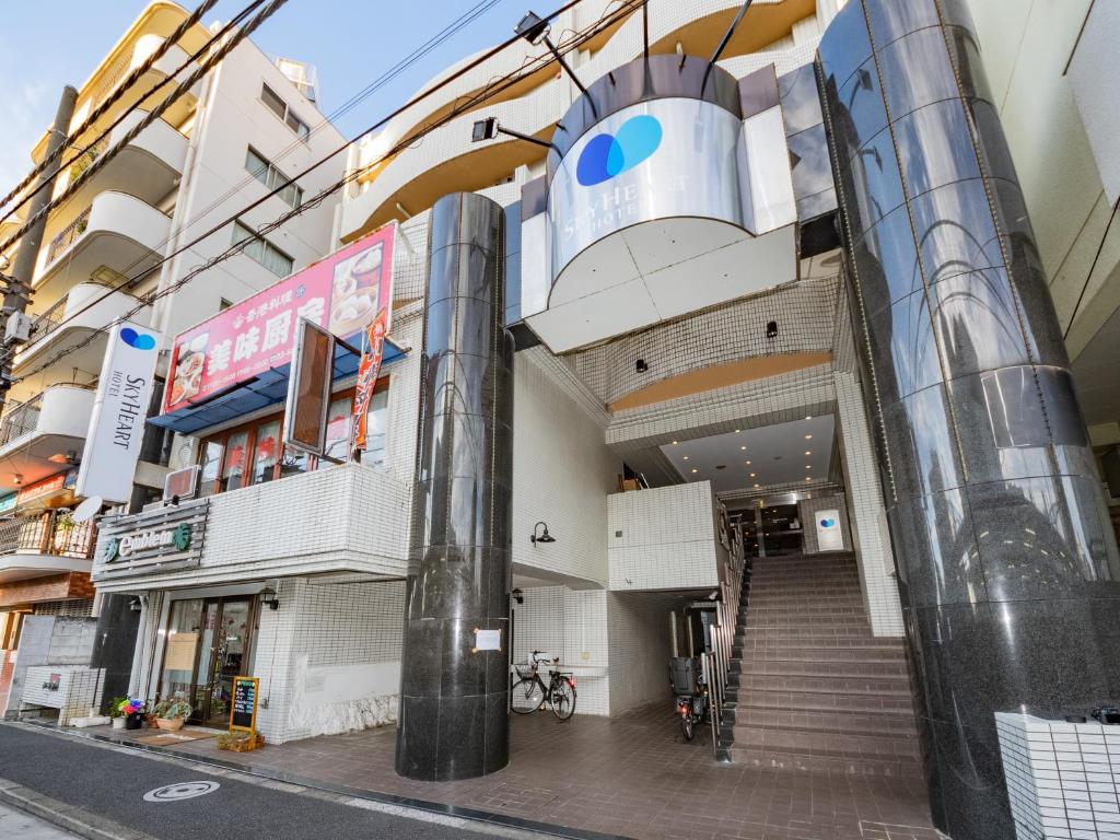 a building with a staircase in the middle of a street at Sky Heart Hotel Koiwa in Tokyo